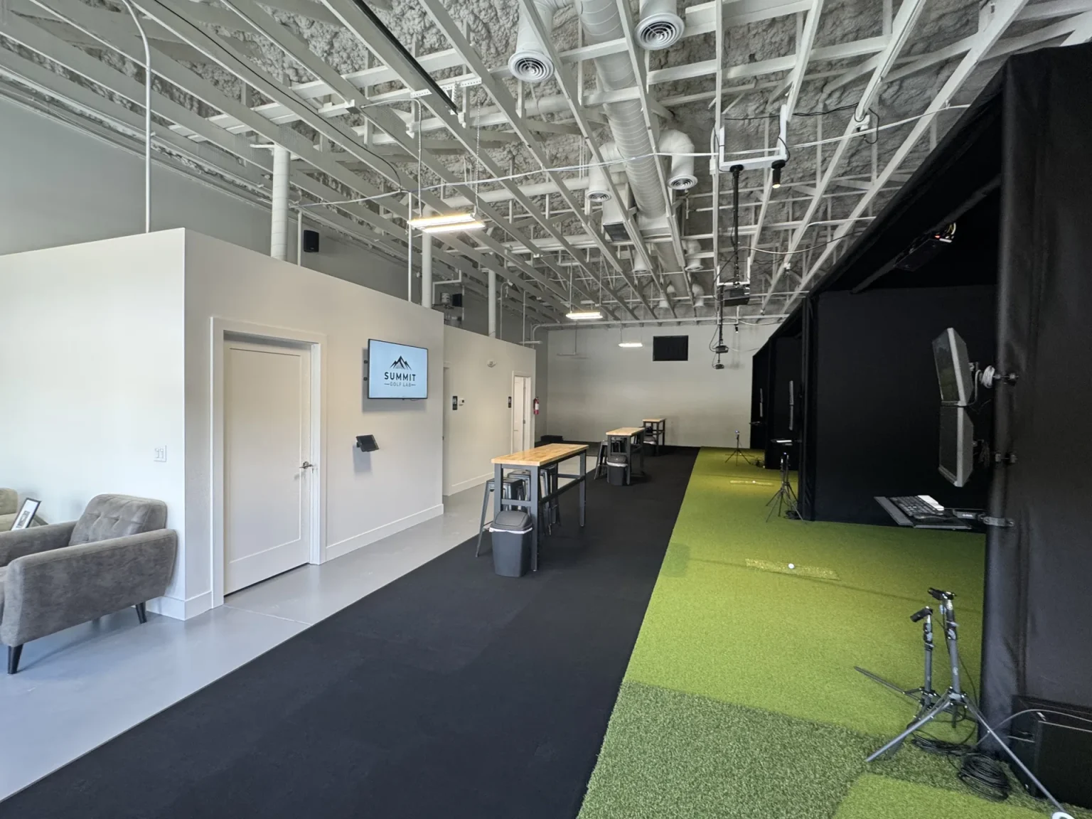 Lounge seating and hitting bays inside Summit Golf Lab